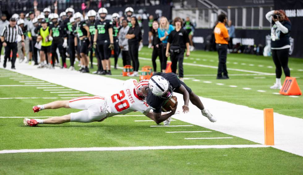 SLAM Academy senior Zekiah Price (9) dives while being tackled by Truckee senior Calvin Curtis ...