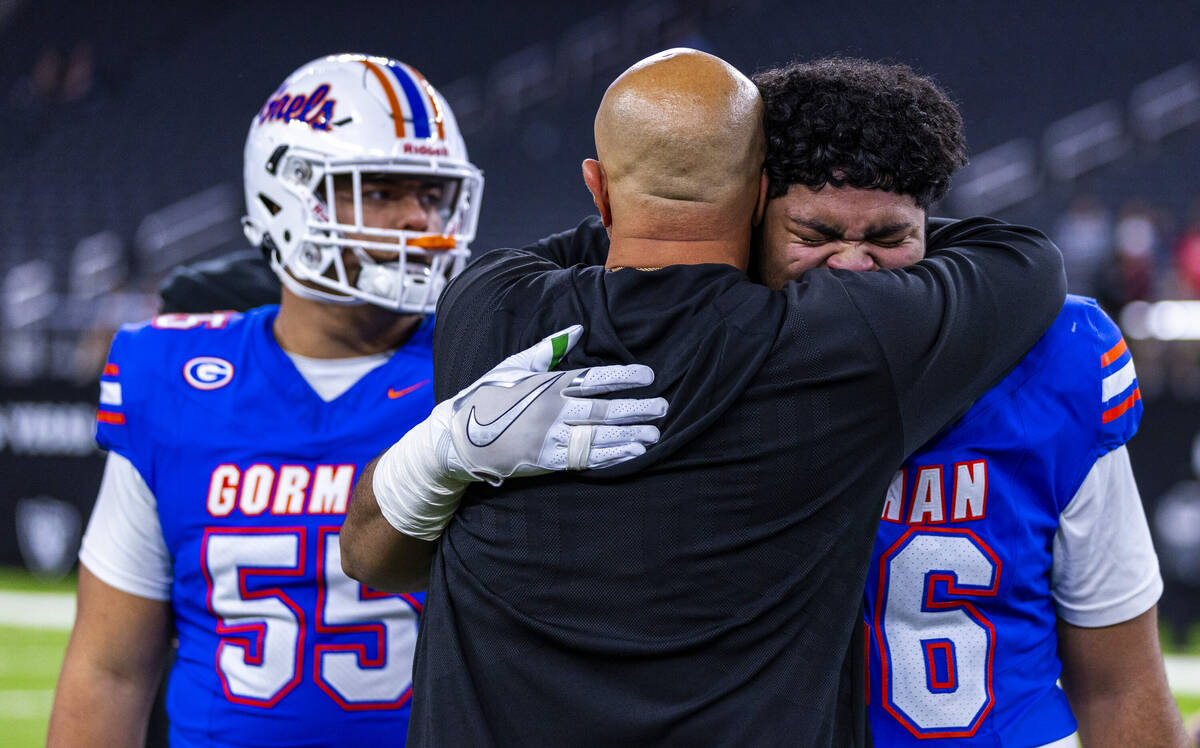 Bishop Gorman offensive lineman Doug Utu (56) cries as a coach hugs him after their 69-7 win ov ...