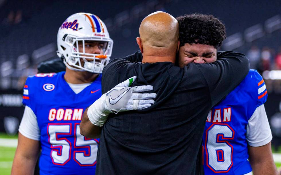 Bishop Gorman offensive lineman Doug Utu (56) cries as a coach hugs him after their 69-7 win ov ...