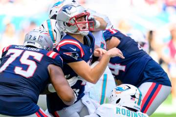 New England Patriots quarterback Drake Maye (10) reacts after throwing the ball and being hit b ...