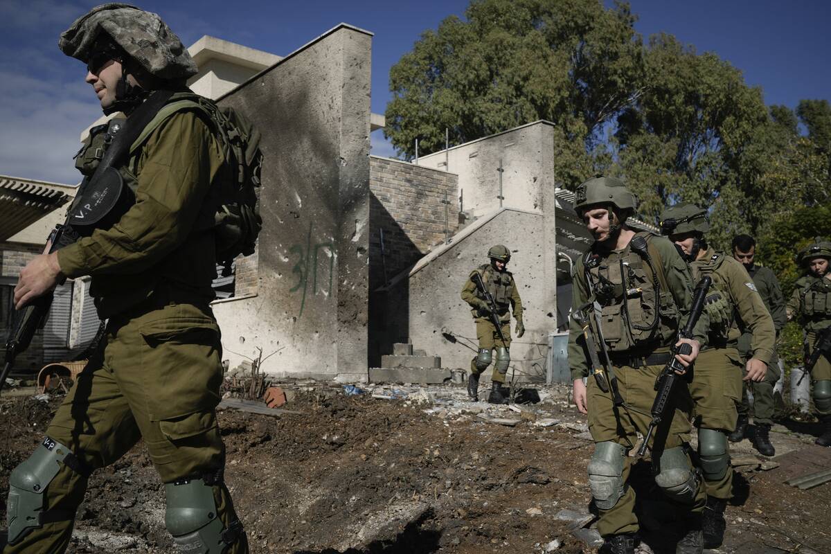 Israeli soldiers inspect the site where a rocket fired from Lebanon landed in a backyard in Kir ...