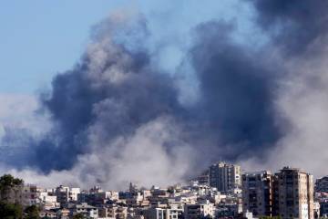 Smoke rises between buildings hit in Israeli airstrikes in Hosh neighbourhood, in Tyre, south L ...