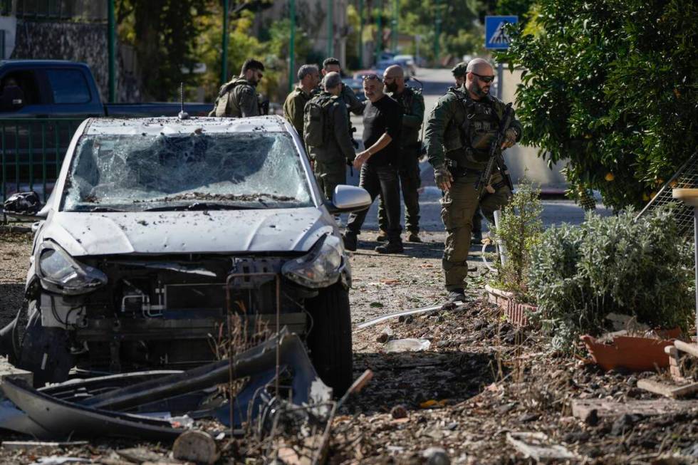 Israeli security officers and army soldiers inspect the site where a rocket fired from Lebanon ...