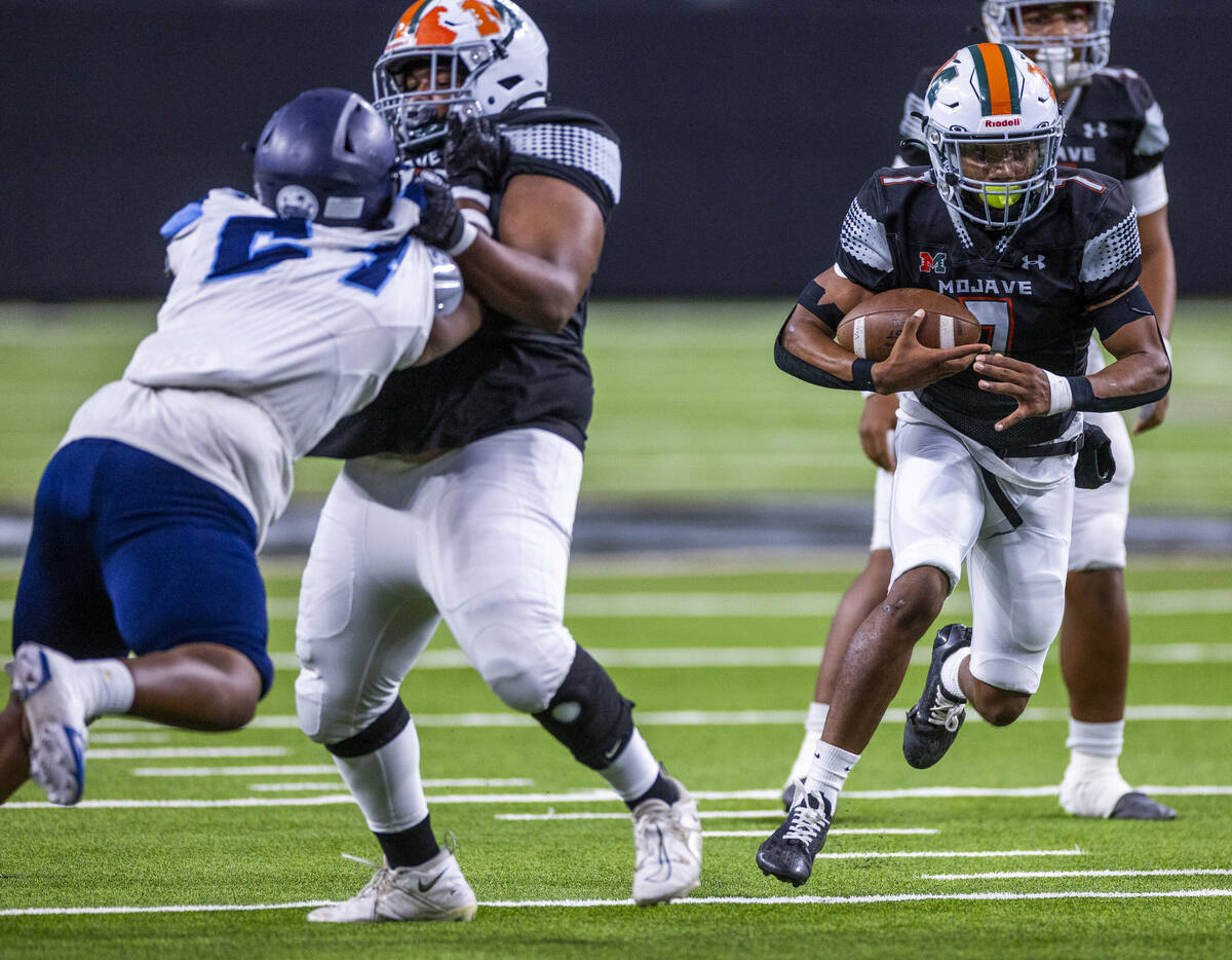 Mojave running back Antwan Hawkins (7) blast through the line against Canyon Springs during the ...