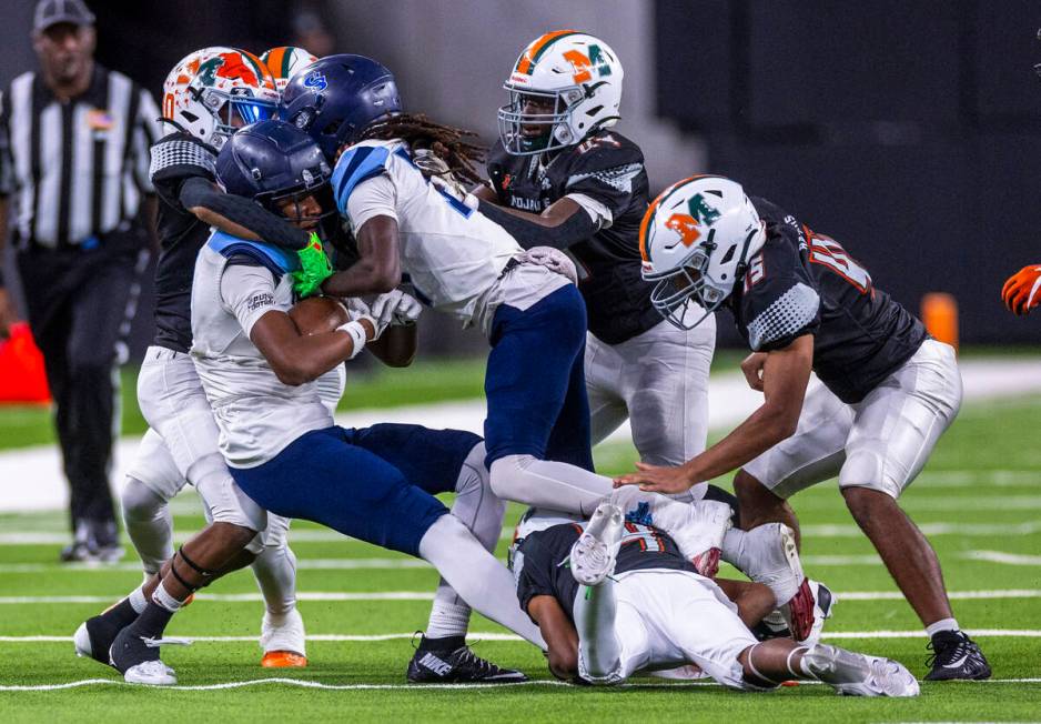 Canyon Springs wide receiver Major Pride (2) is tackled by Mojave safety D'terrion Bowman (10) ...