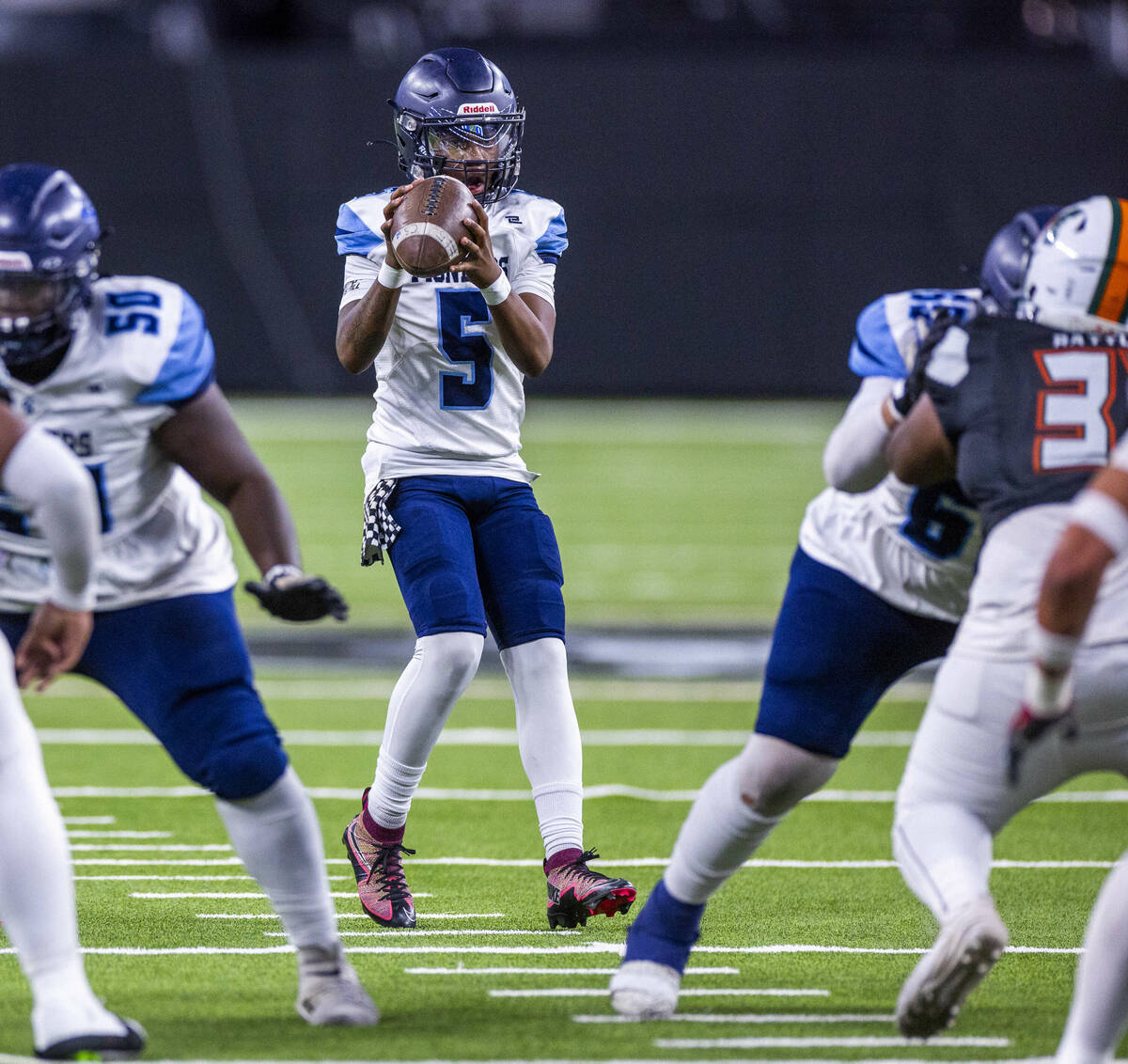 Canyon Springs quarterback Tysean McCraney (5) takes a snap against Mojave during the first hal ...