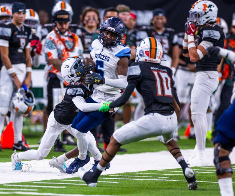 Canyon Springs quarterback Tysean McCraney (5) is tackled on a run by Mojave defensive back Dem ...