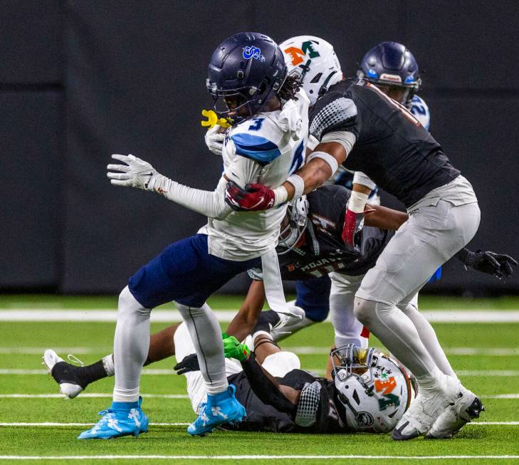 Canyon Springs running back Amere Swan (3) is stopped by Mojave defender Albert AJ Tuitele (11) ...