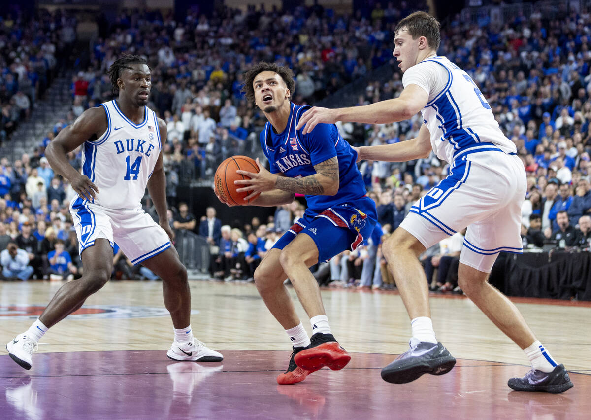 Kansas Jayhawks guard Zeke Mayo, center, rushes to the hoop during the Vegas Showdown college b ...