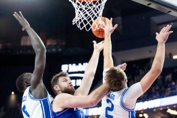 Kansas Jayhawks center Hunter Dickinson, center, attempts a layup during the Vegas Showdown col ...