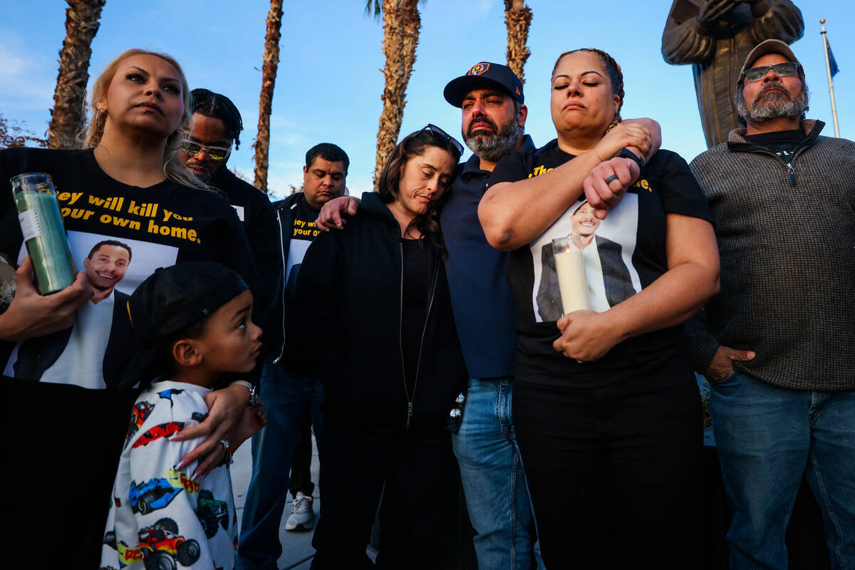 Friends and family close their eyes for a moment of silence during a vigil for Brandon Durham, ...