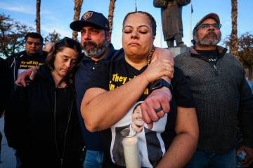 Alli Cossio, from left, Adrian Cossio and Rachael Gore take in a moment of silence during a vig ...