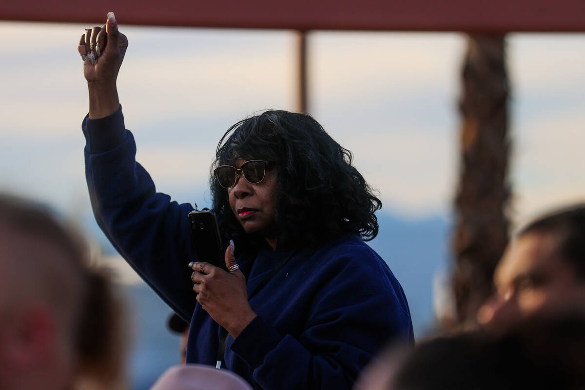 A mourner raises their fist during a vigil for Brandon Durham, who was shot and killed in his h ...