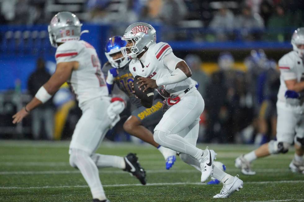 UNLV quarterback Hajj-Malik Williams, center, runs the ball during the first half of an NCAA co ...