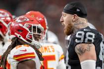 Kansas City Chiefs running back Kareem Hunt (29) and Raiders defensive end Maxx Crosby (98) exc ...