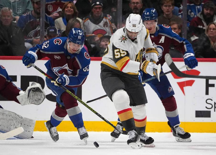 Vegas Golden Knights right wing Keegan Kolesar, center, struggles to control the puck as Colora ...