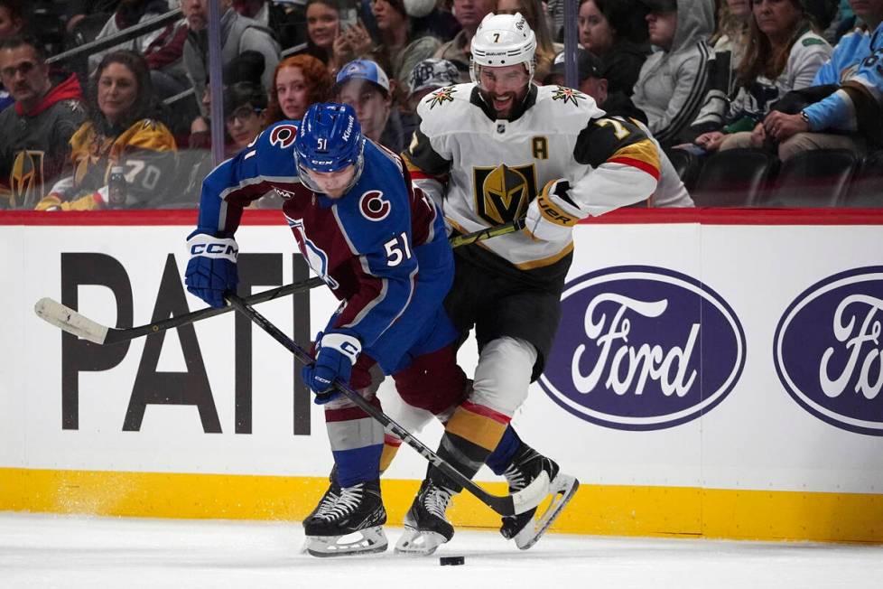 Colorado Avalanche right wing Nikolai Kovalenko, left, gets tangled up with Vegas Golden Knight ...