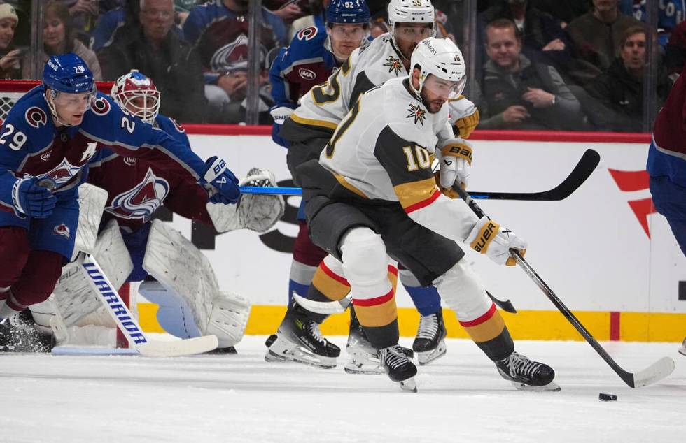 Vegas Golden Knights center Nicolas Roy, right, collects the puck as Colorado Avalanche center ...