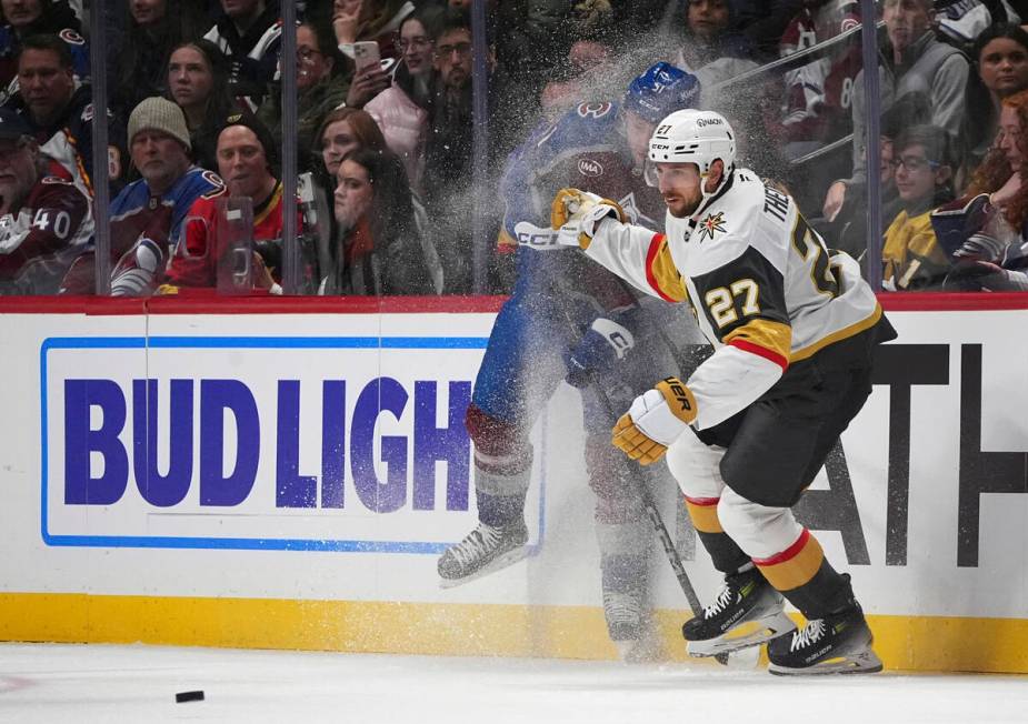 Vegas Golden Knights defenseman Shea Theodore, front, checks Colorado Avalanche right wing Niko ...