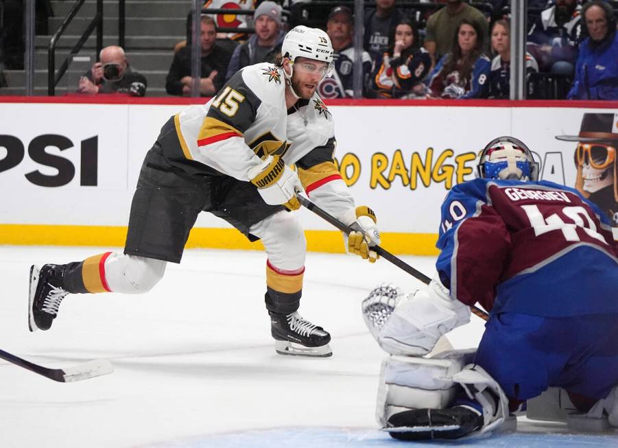 Vegas Golden Knights defenseman Noah Hanifin, back, puts a shot on Colorado Avalanche goaltende ...