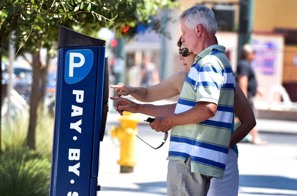 FILE - Tourists Marv and Jean Junk of Iowa feed a parking meter along 7th Street in downtown La ...