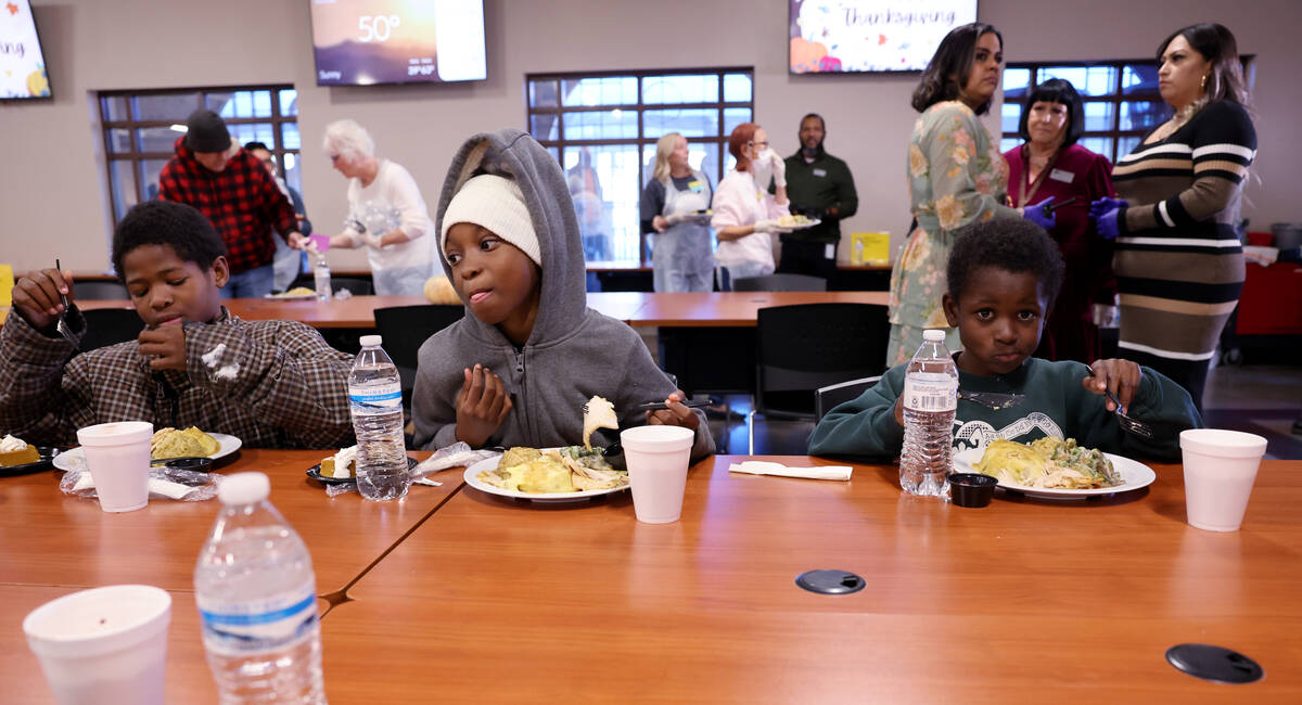 Siblings, from left, Rayvontae, 11, Lamyajuah,10, and Kadontae Moore, 7, eat with their family ...