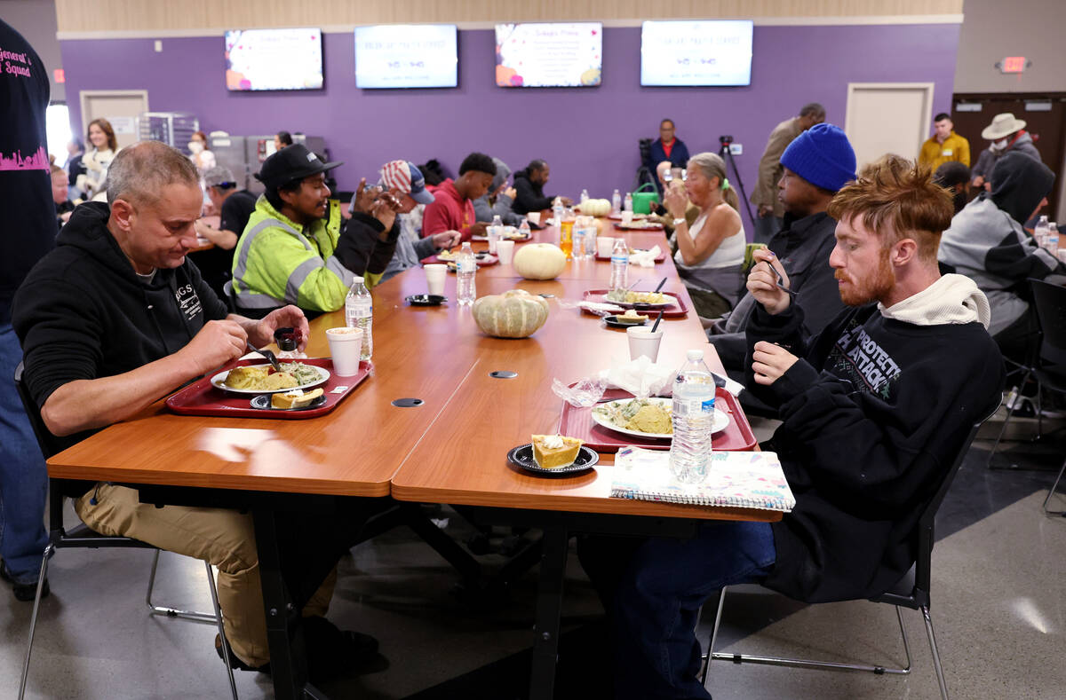 Guests, including Garret Best, 43, left, and Michael Buskirk, 24, eat during the Catholic Chari ...