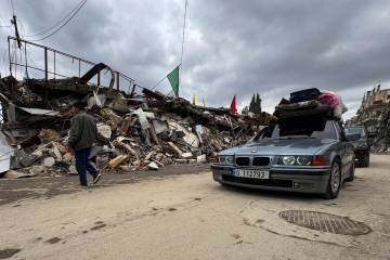 Displaced residents drive past destroyed buildings as they return to Nabatiyeh, southern Lebano ...