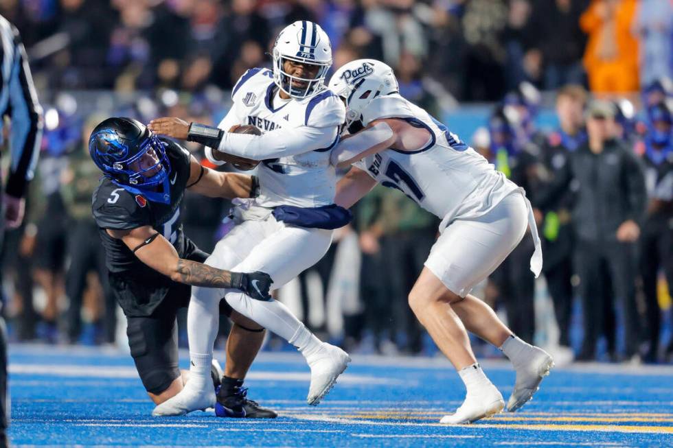 Nevada quarterback Brendon Lewis (2) tries to spin away from Boise State defensive end Jayden V ...