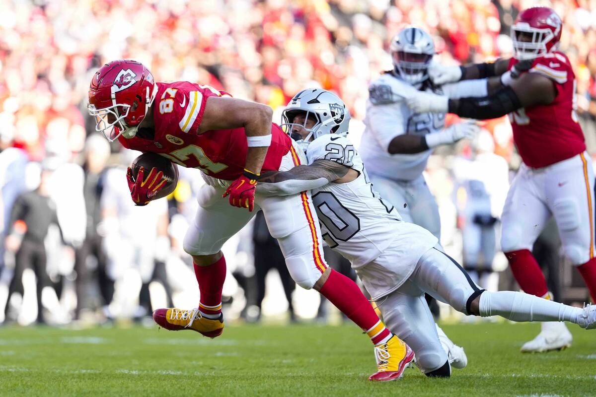 Kansas City Chiefs tight end Travis Kelce (87) is tackled by Las Vegas Raiders safety Isaiah Po ...