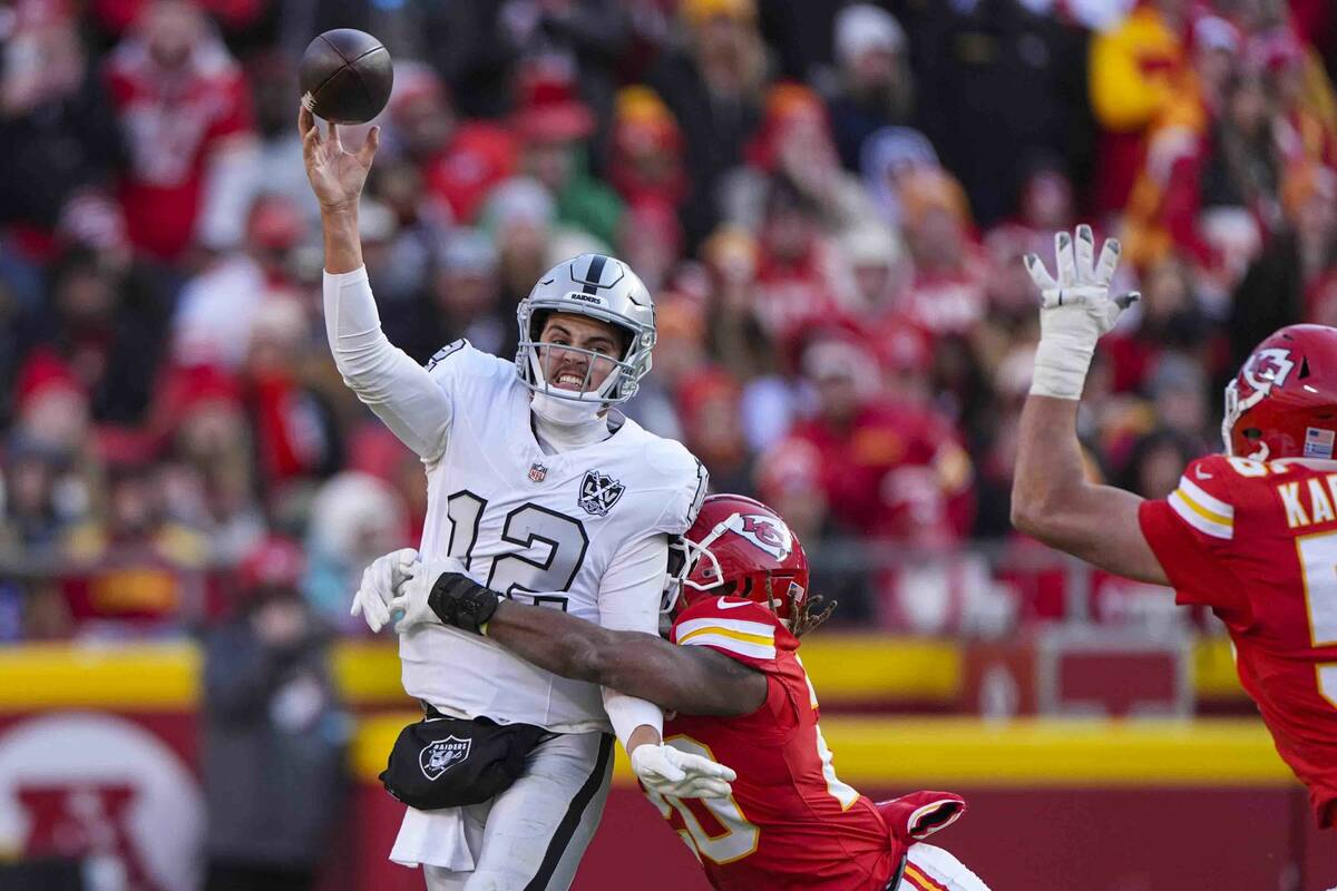 Las Vegas Raiders quarterback Aidan O'Connell (12) is hit by Kansas City Chiefs safety Justin R ...