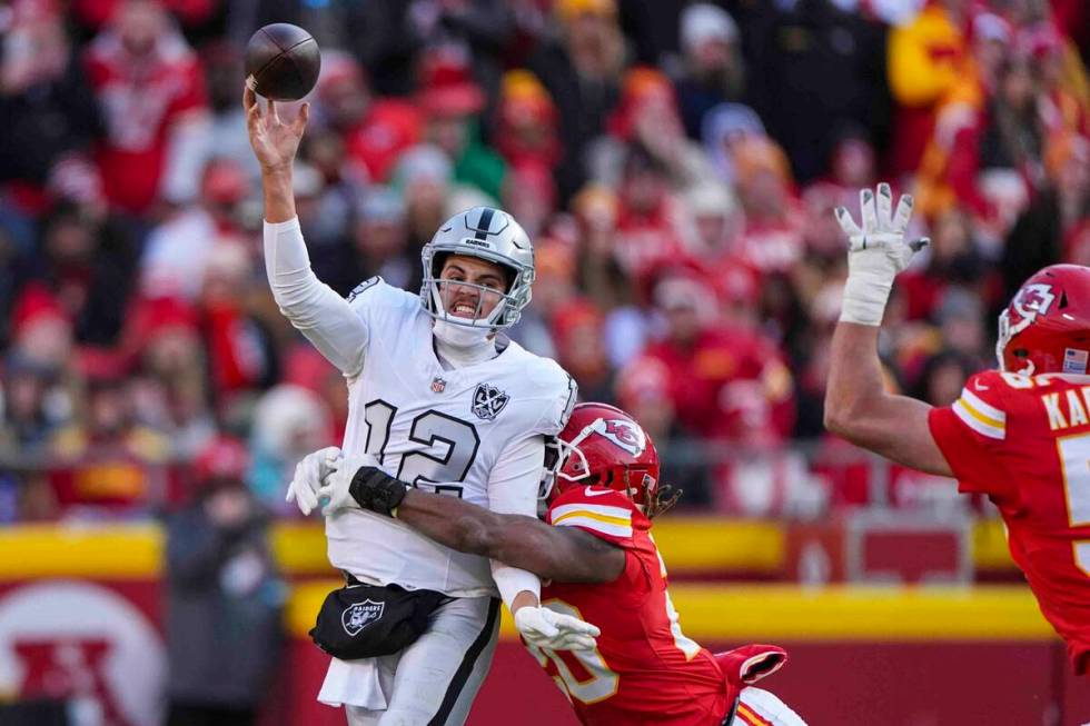 Las Vegas Raiders quarterback Aidan O'Connell (12) is hit by Kansas City Chiefs safety Justin R ...