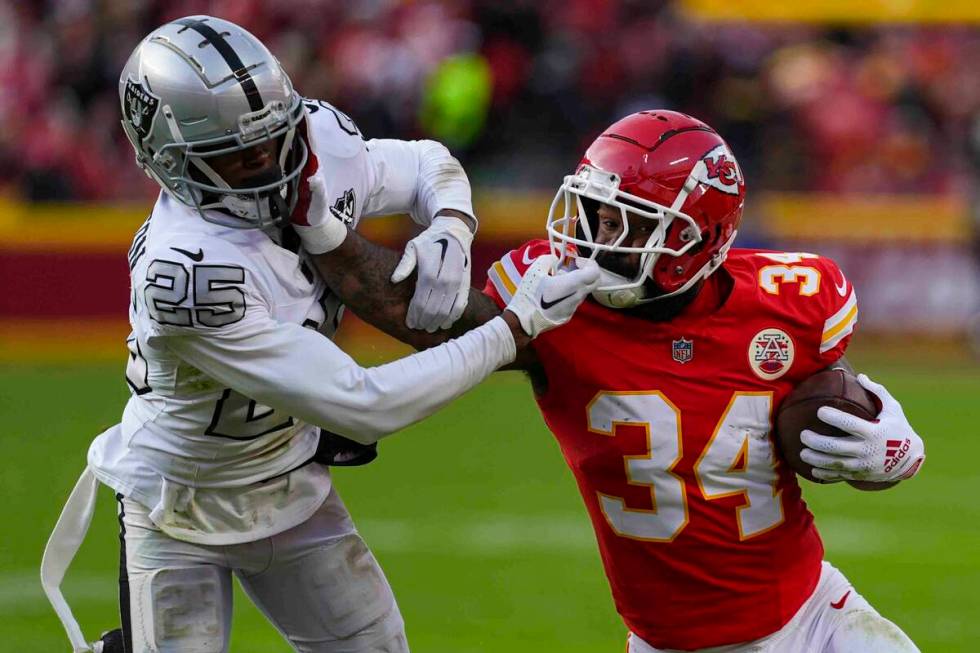 Kansas City Chiefs running back Samaje Perine (34) tries to hold off Las Vegas Raiders cornerba ...