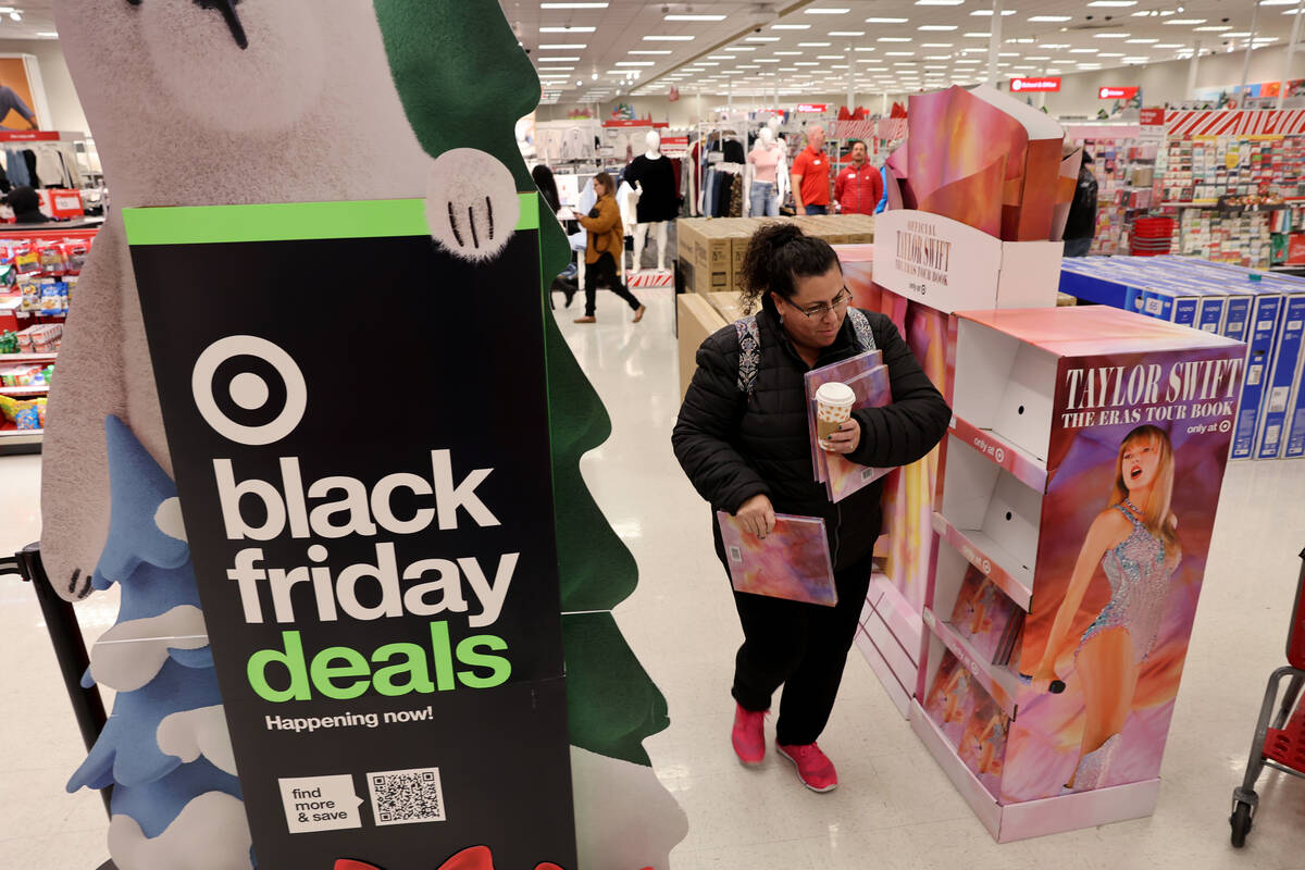 Black Friday shoppers grab the Taylor Swift Eras Tour book at the 6 a.m. opening of the Target ...