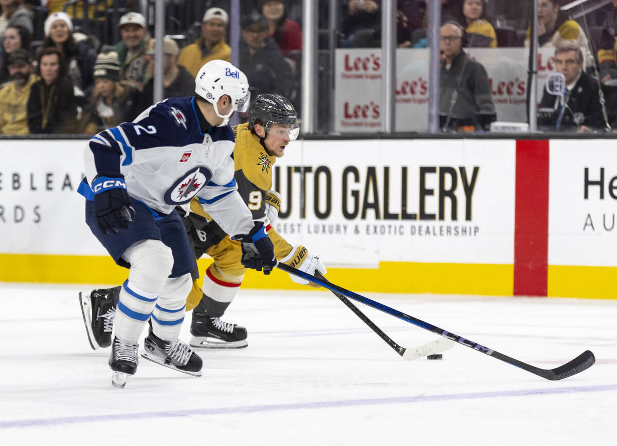 Golden Knights center Jack Eichel (9) attempts to pass Winnipeg Jets defenseman Dylan DeMelo (2 ...