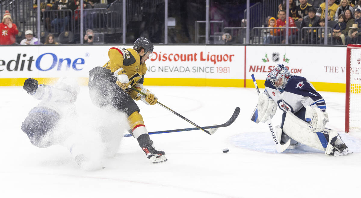 Golden Knights center Brett Howden (21) looks to shoot the puck past Winnipeg Jets goaltender E ...