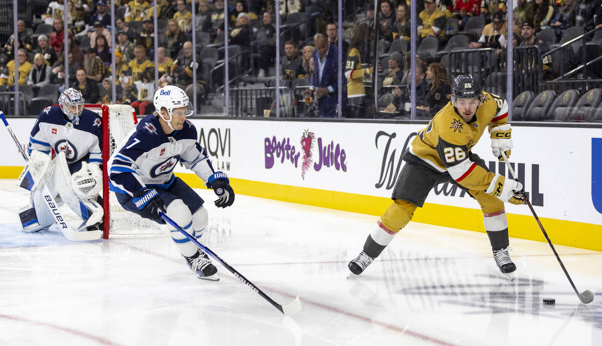 Golden Knights right wing Alexander Holtz (26) keeps the puck from Winnipeg Jets center Vladisl ...