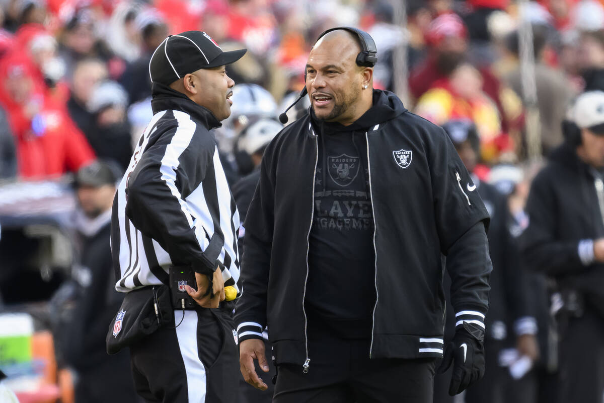 Las Vegas Raiders head coach Antonio Pierce, right, talks to side judge Greg Gautreaux, left, d ...