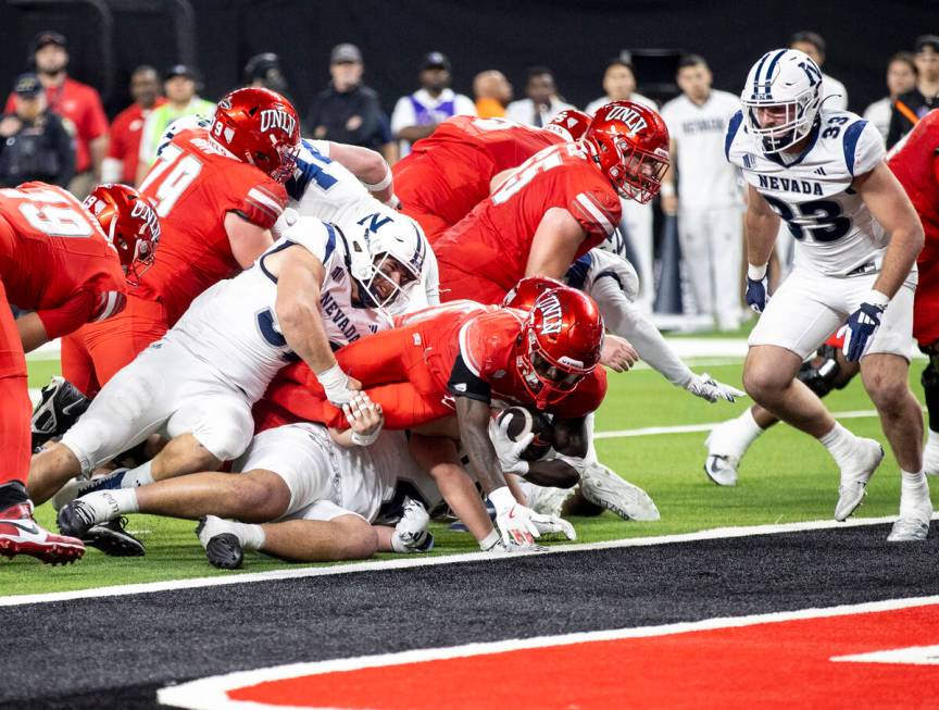 UNLV running back Jai'Den Thomas, center, dives to score a touchdown during the NCAA college fo ...