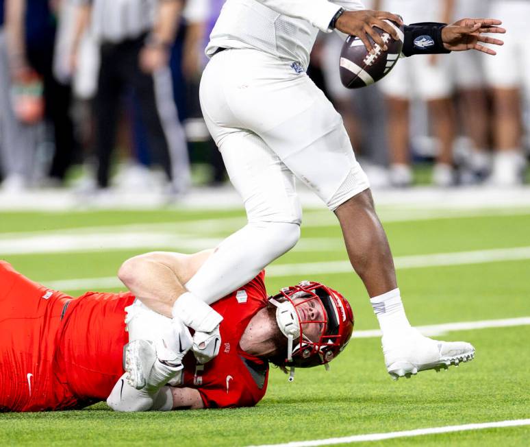 UNLV defensive lineman Fisher Camac, bottom, holds onto UNR quarterback Brendon Lewis, top, dur ...