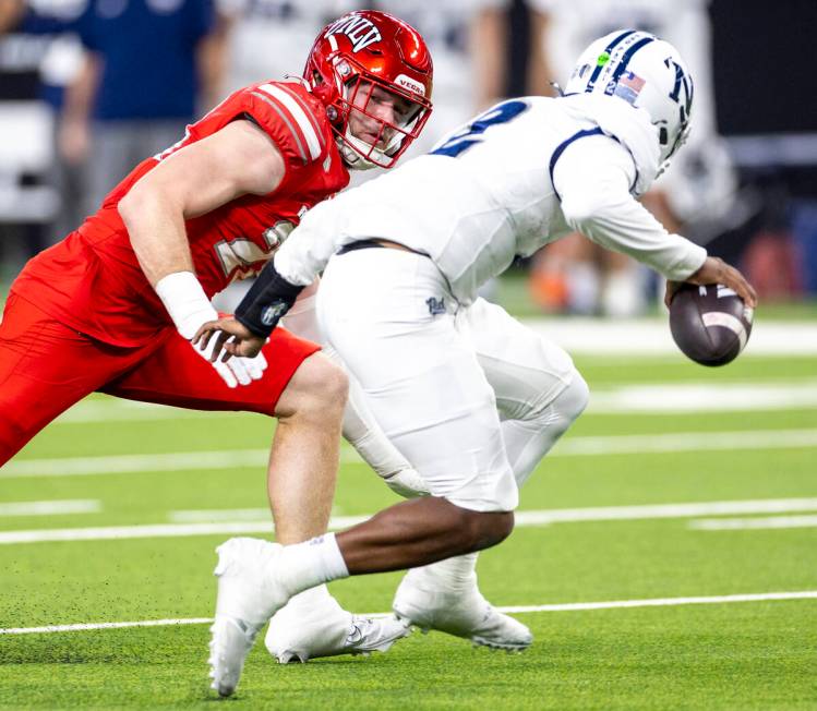 UNLV defensive lineman Fisher Camac, left, looks to tackle UNR quarterback Brendon Lewis (2) du ...