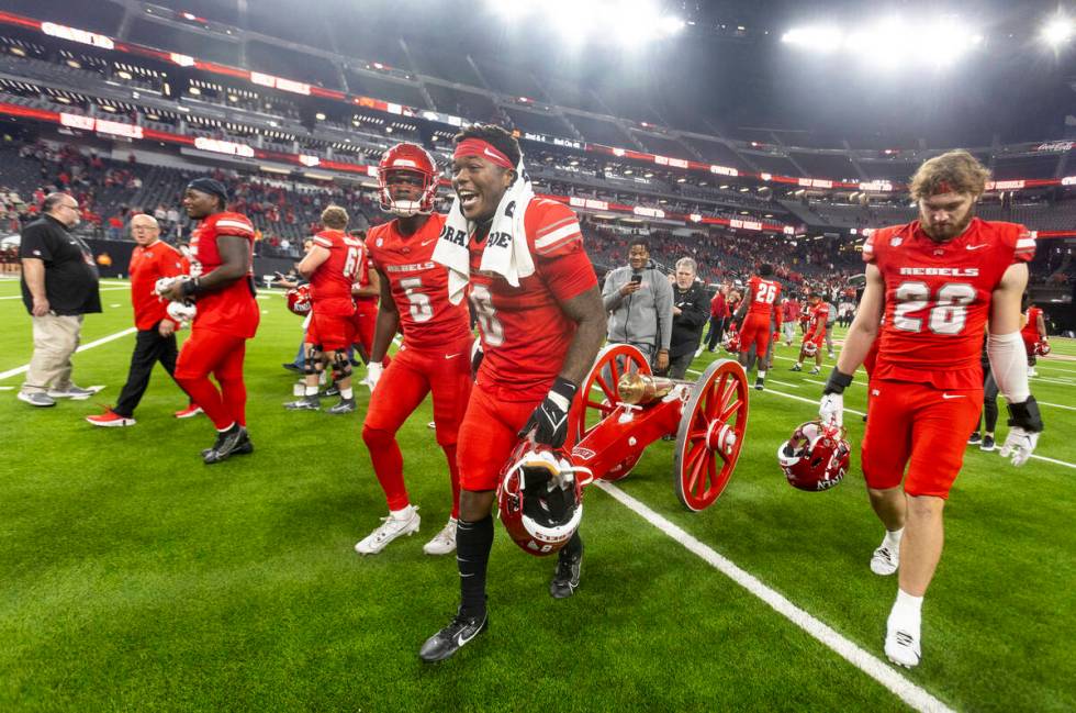 UNLV running back Greg Burrell (5) and linebacker Marsel McDuffie (8) wheel the Fremont Cannon ...