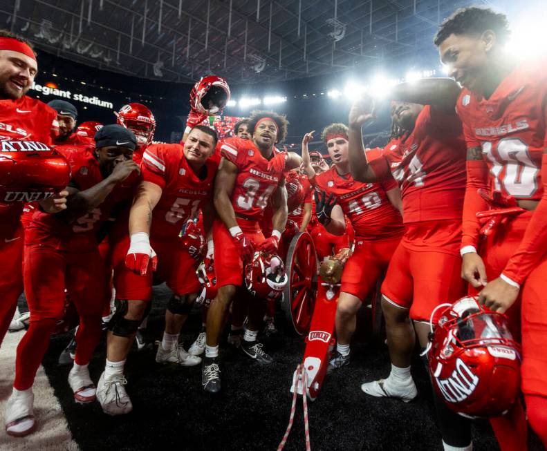 UNLV players dance with the Fremont Cannon after winning the NCAA college football game against ...