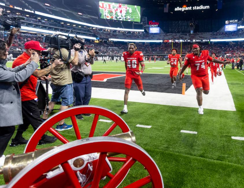 UNLV players run to the Fremont Cannon after winning the NCAA college football game against UNR ...