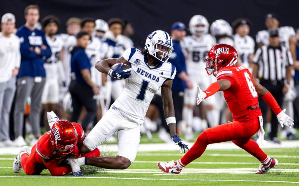 UNR wide receiver Jaden Smith (1) is tackled by UNLV defensive back La'Vario Wiley, left, durin ...