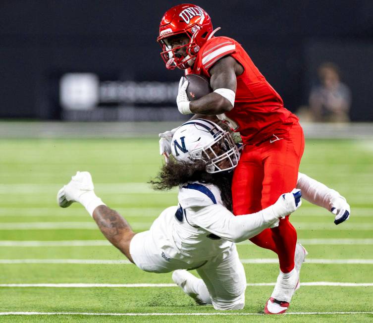 UNR linebacker Tongiaki Mateialona, left, attempts to tackle UNLV running back Jai'Den Thomas ( ...