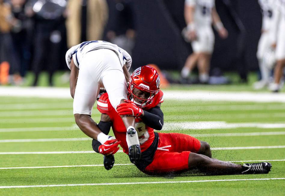 UNLV defensive back Jett Elad (9) tackles UNR running back Ky Woods, left, during the NCAA coll ...