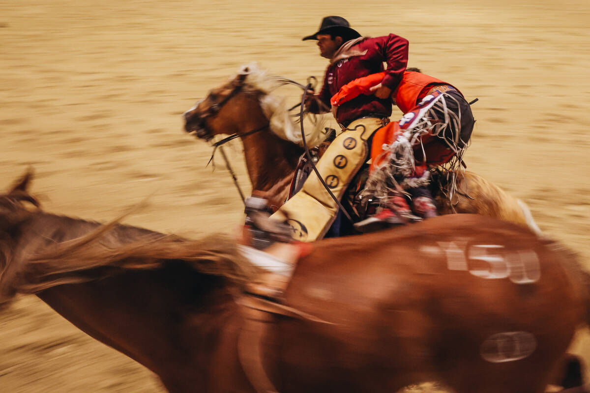 Rodeo cowboy Rocker Steiner is helped off of a horse by a pickup man during the bareback riding ...