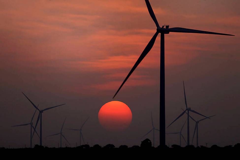 FILE - The sun sets at wind farm in McCook, Texas during a heat wave on July 20, 2022. (Delcia ...