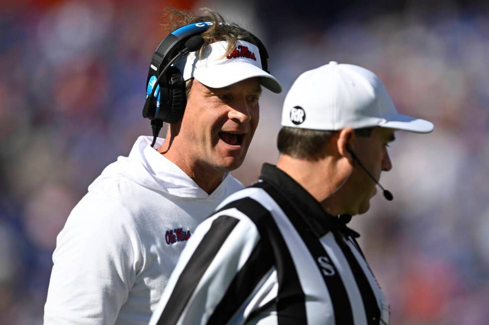 Mississippi head coach Lane Kiffin, left, questions an official on the sideline during the firs ...